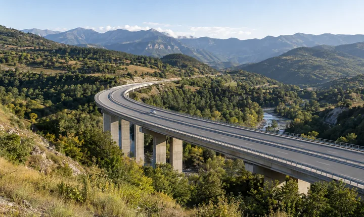 A divided highway curves across a viaduct through Georgia's green foothills