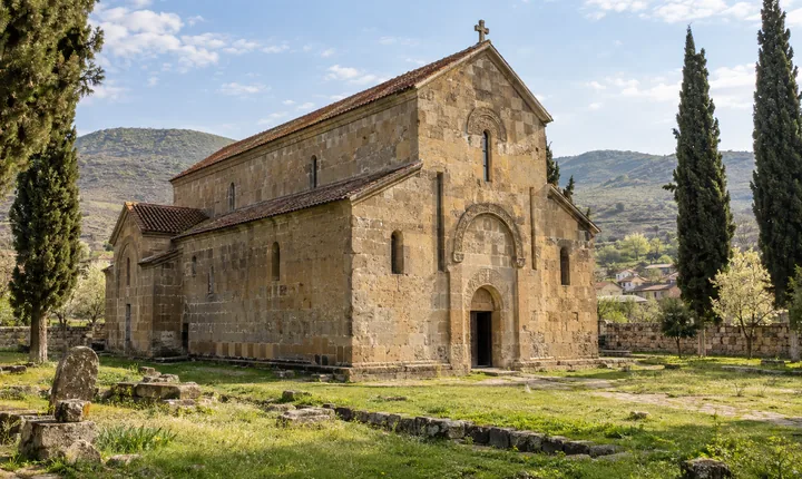 Bolnisi Sioni's golden stone basilica in a quiet grassy courtyard in Kvemo Kartli