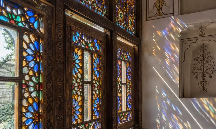 Geometric colored glass and carved timber in a traditional Sheki window