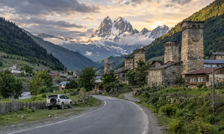A paved road approaches Mestia's stone towers beneath the peaks of Svaneti