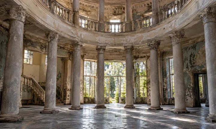Sunlight falls across weathered columns and tiled floors in a Tskaltubo sanatorium hall