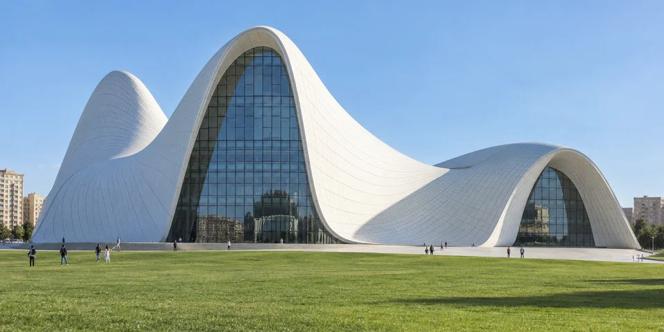 Белый изогнутый Heydar Aliyev Center над зелёной лужайкой в Baku