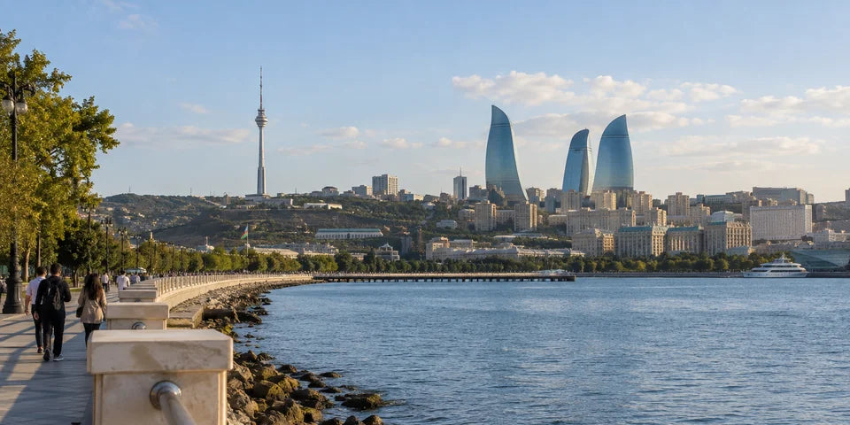 Spaziergänger am Kaspischen Meer mit der Skyline von Baku in der Ferne