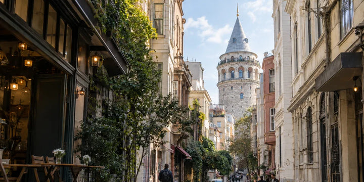 Piesi na brukowanej ulicy pod wieżą Galata w Istanbul