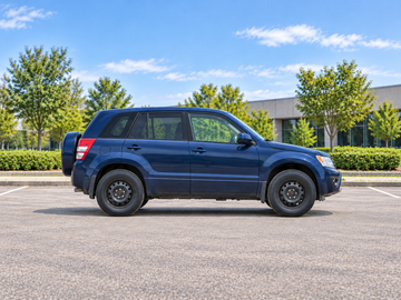 AI-generated illustrative Suzuki Grand Vitara (JT, 5-door) 2013, side profile in a dry paved city setting. Actual vehicle colour and equipment may vary.