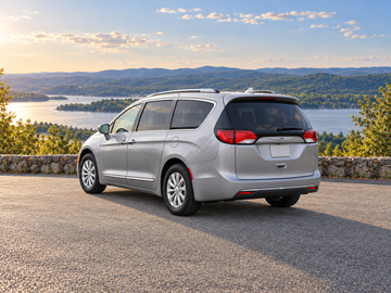 AI-generated illustrative Chrysler Pacifica 2018, rear three-quarter in a dry paved scenic setting. Actual vehicle colour and equipment may vary.