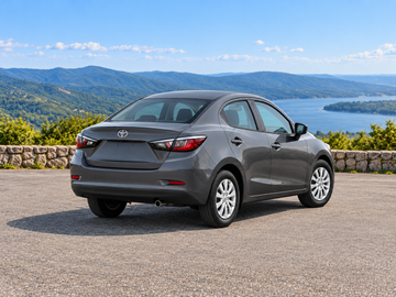KI-generierte illustrative Darstellung: Toyota Yaris Sedan 2019, hintere Dreiviertelansicht auf trockenem Straßenbelag in landschaftlicher Umgebung. Farbe und Ausstattung des tatsächlichen Fahrzeugs können abweichen.